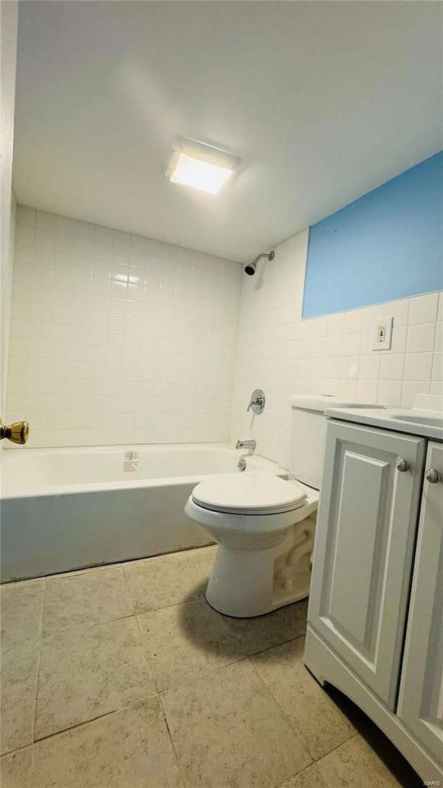 bathroom featuring vanity, tile walls, and toilet