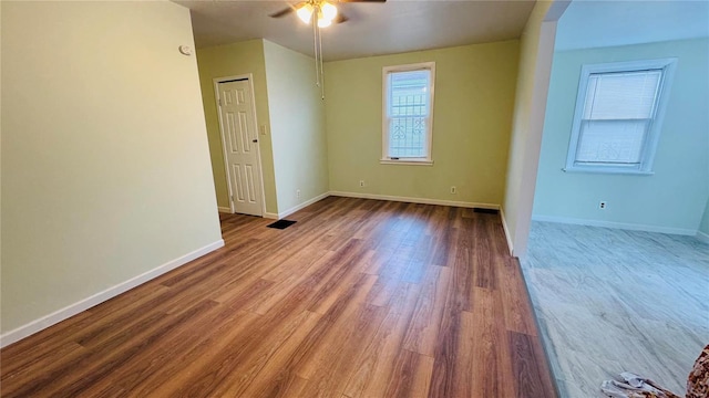 spare room featuring wood-type flooring and ceiling fan