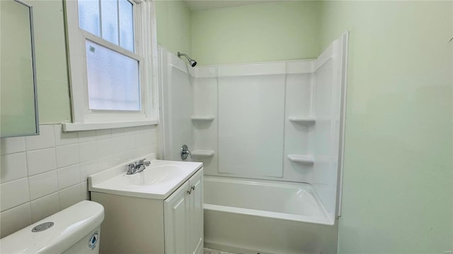 full bathroom featuring vanity, shower / washtub combination, tile walls, and toilet