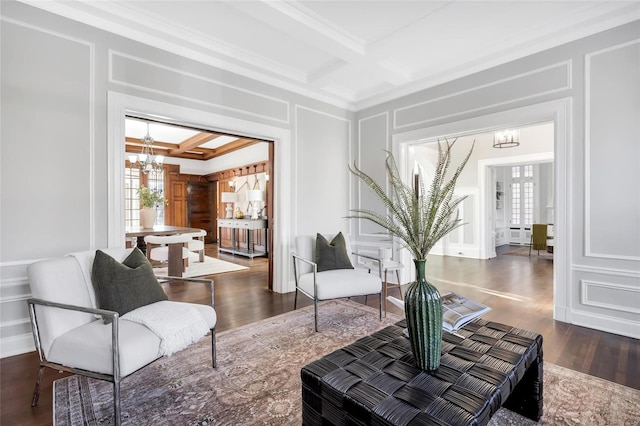 sitting room with ornamental molding, coffered ceiling, beam ceiling, an inviting chandelier, and dark hardwood / wood-style floors