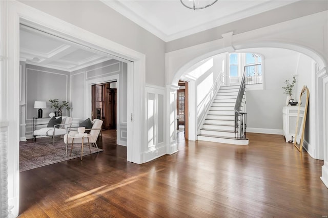 entryway featuring beamed ceiling, ornamental molding, dark wood-type flooring, and coffered ceiling