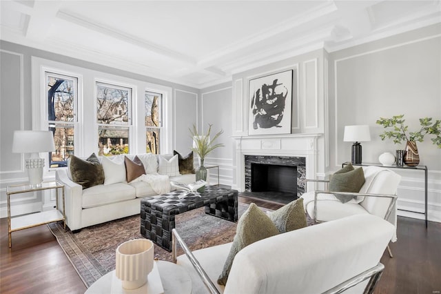 living room featuring beam ceiling, coffered ceiling, dark hardwood / wood-style floors, a fireplace, and ornamental molding