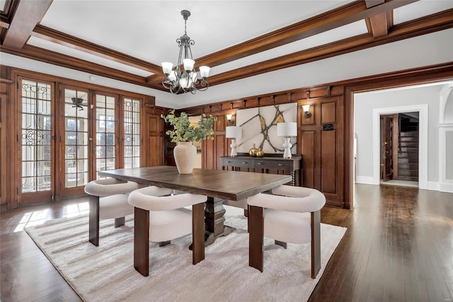 dining room with coffered ceiling, dark hardwood / wood-style flooring, crown molding, and a chandelier