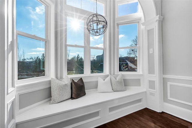 sitting room with a chandelier and dark wood-type flooring