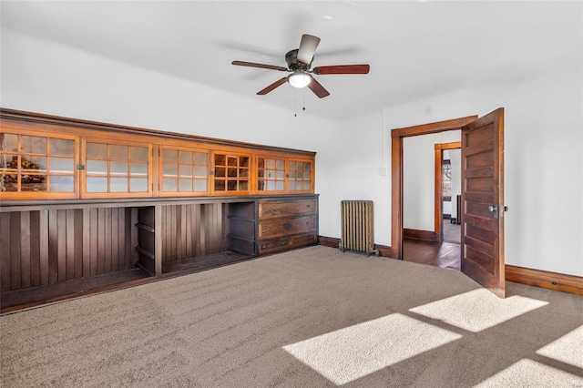 interior space featuring radiator, ceiling fan, and dark colored carpet