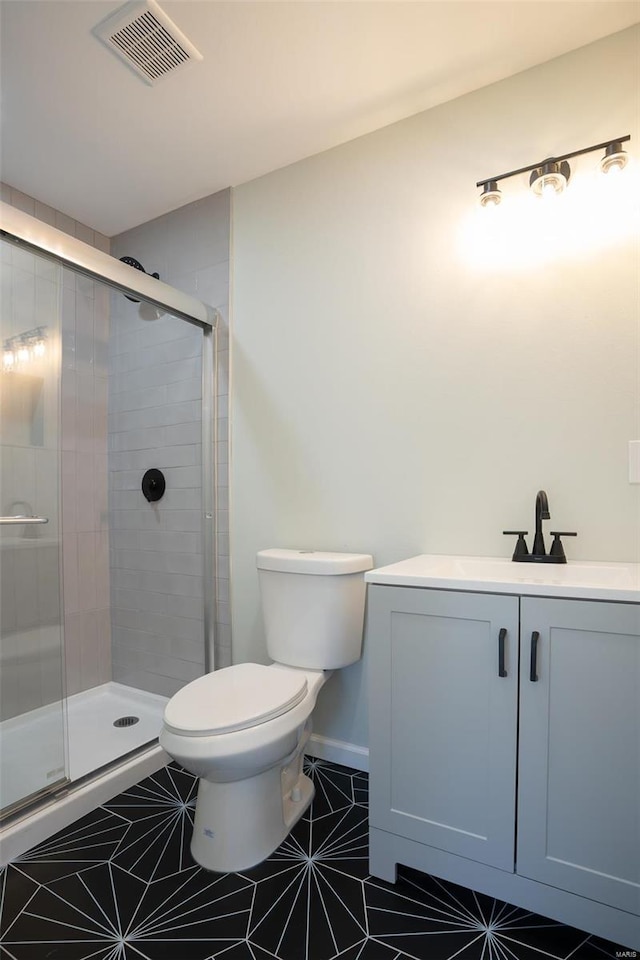 bathroom featuring tile patterned floors, walk in shower, vanity, and toilet