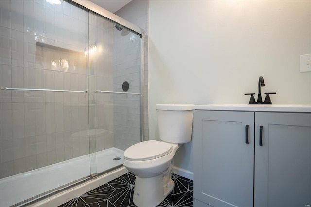 bathroom featuring tile patterned flooring, vanity, a shower with door, and toilet