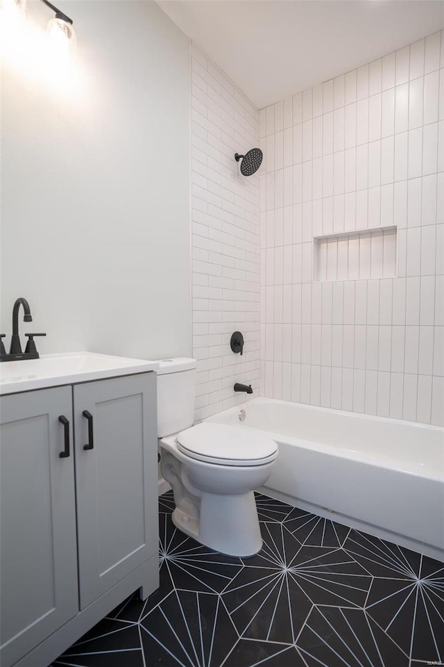 full bathroom with tile patterned flooring, vanity, toilet, and tiled shower / bath combo