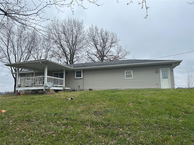 rear view of property featuring a yard and a porch