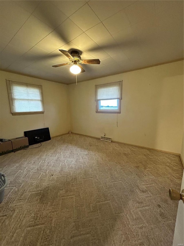 carpeted spare room with ceiling fan