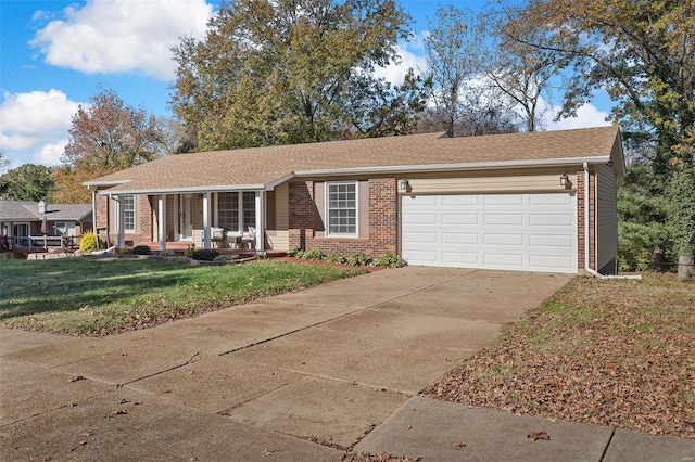 ranch-style house featuring a porch, a front yard, and a garage