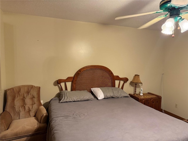 bedroom with ceiling fan and a textured ceiling