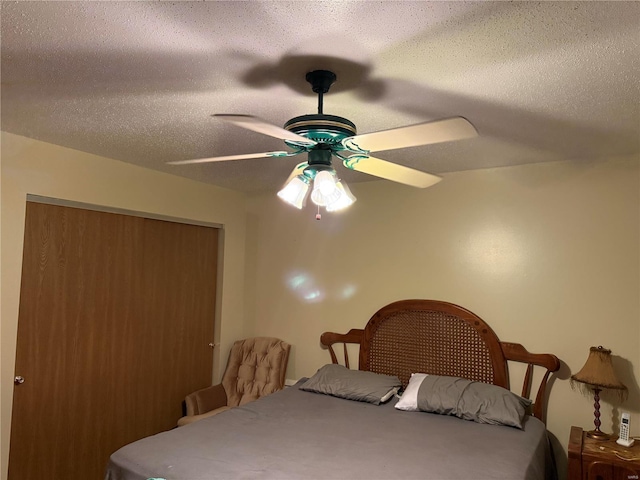 bedroom with a textured ceiling, a closet, and ceiling fan