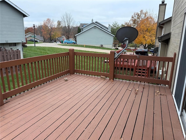 wooden deck featuring a lawn