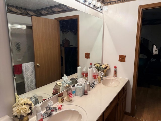 bathroom with walk in shower, vanity, a textured ceiling, and hardwood / wood-style flooring