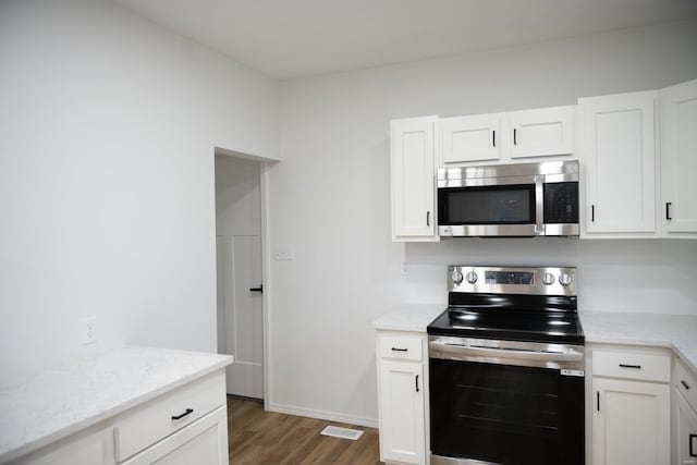 kitchen with white cabinets, dark hardwood / wood-style flooring, and stainless steel appliances