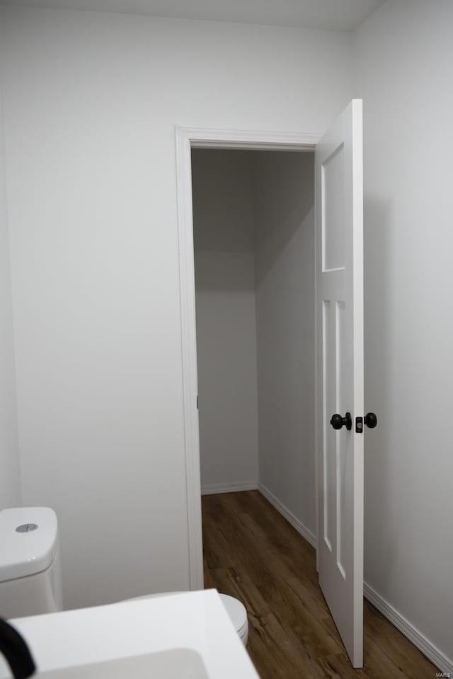 bathroom featuring wood-type flooring and toilet