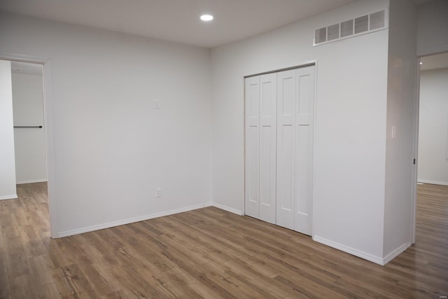 unfurnished bedroom featuring a closet and hardwood / wood-style flooring