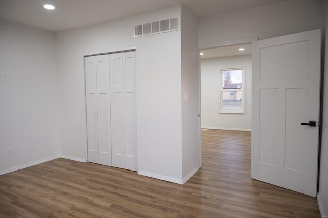 unfurnished bedroom with a closet and dark hardwood / wood-style floors