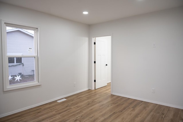 unfurnished room with hardwood / wood-style flooring