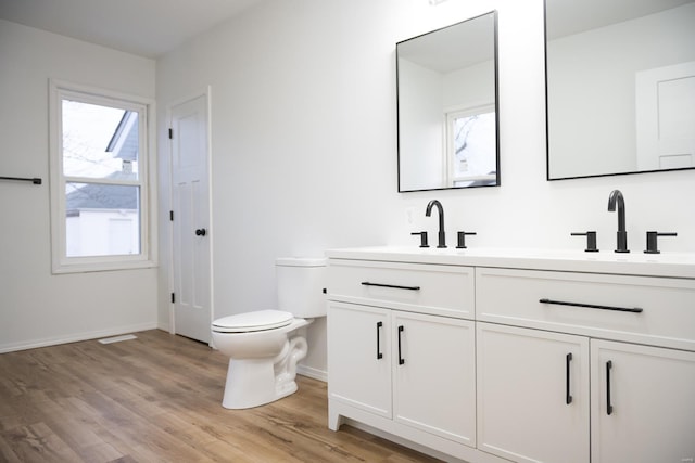 bathroom with hardwood / wood-style floors, vanity, and toilet