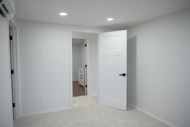 bedroom featuring a wall mounted air conditioner and light colored carpet