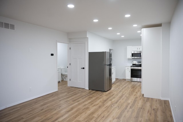 kitchen featuring white cabinets, light wood-type flooring, and appliances with stainless steel finishes