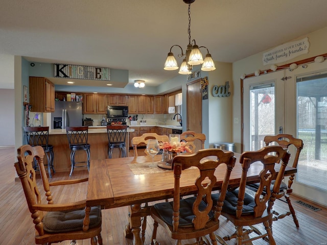 dining space with light wood-type flooring, french doors, visible vents, and baseboards