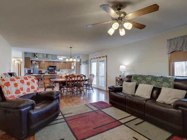 living room featuring light wood-type flooring and a ceiling fan