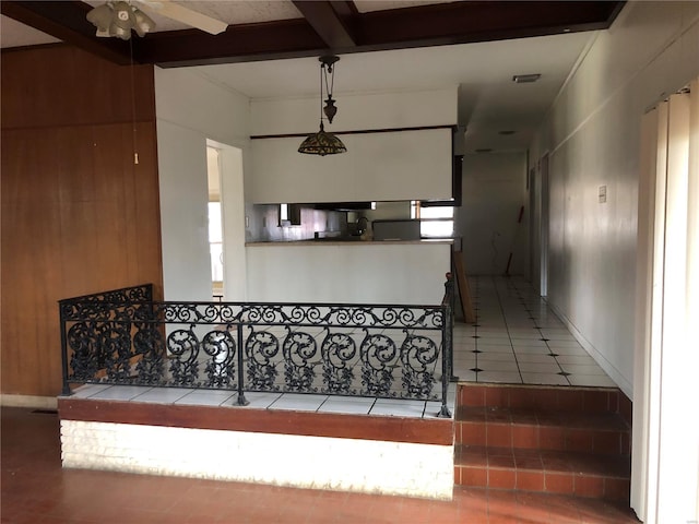 stairway with ceiling fan, tile patterned flooring, beamed ceiling, and coffered ceiling