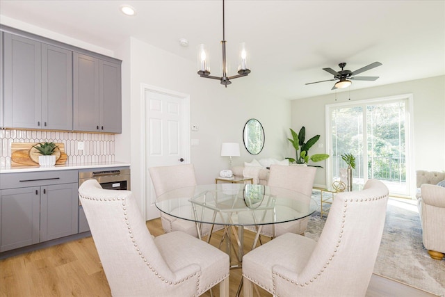 dining space featuring ceiling fan with notable chandelier and light hardwood / wood-style floors