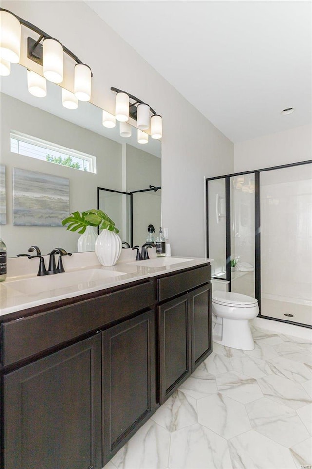 bathroom with vanity, toilet, and a shower with shower door