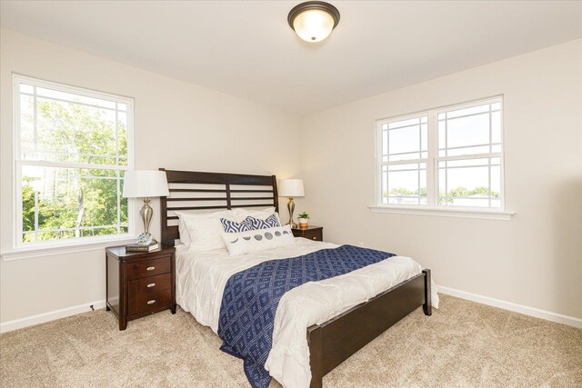 carpeted bedroom featuring multiple windows