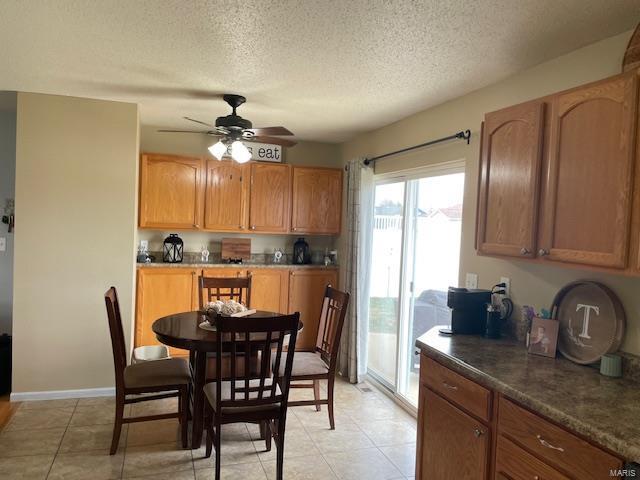 kitchen featuring light tile patterned floors, a textured ceiling, and ceiling fan