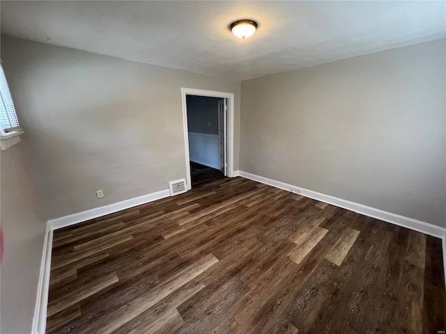 spare room with dark wood-type flooring