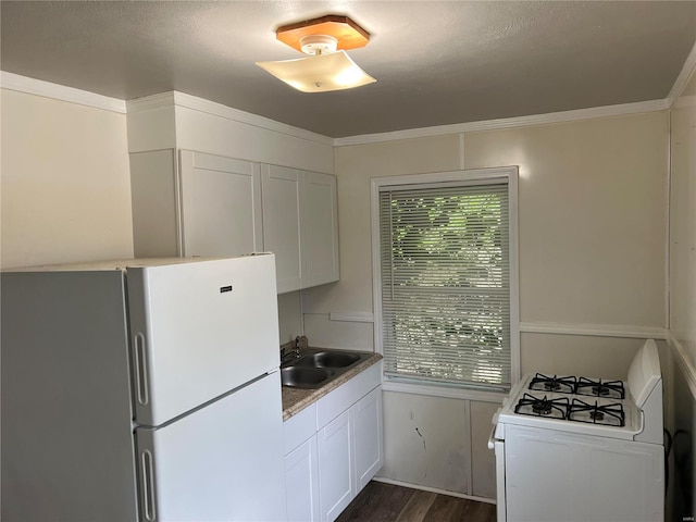 kitchen featuring ornamental molding, white appliances, dark wood-type flooring, sink, and white cabinetry