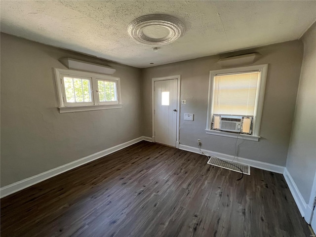 foyer featuring cooling unit, dark wood-type flooring, and a textured ceiling