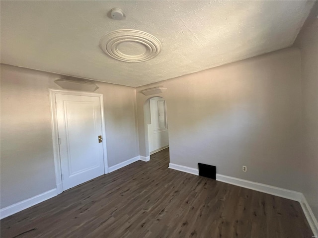 unfurnished room with dark wood-type flooring