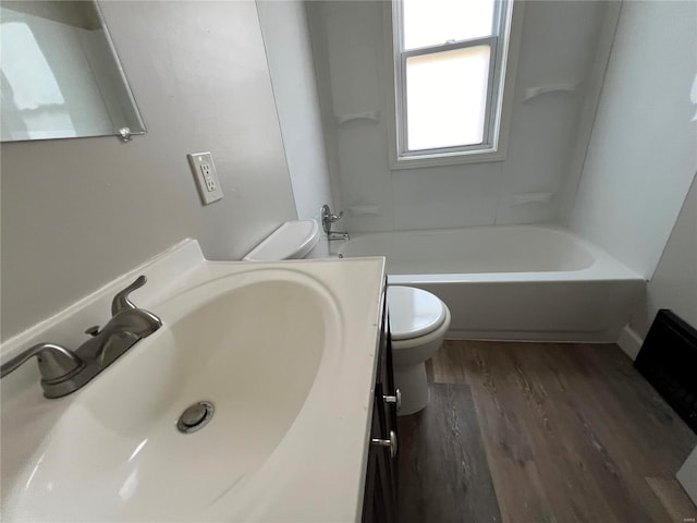 full bathroom featuring hardwood / wood-style flooring, vanity, toilet, and shower / washtub combination