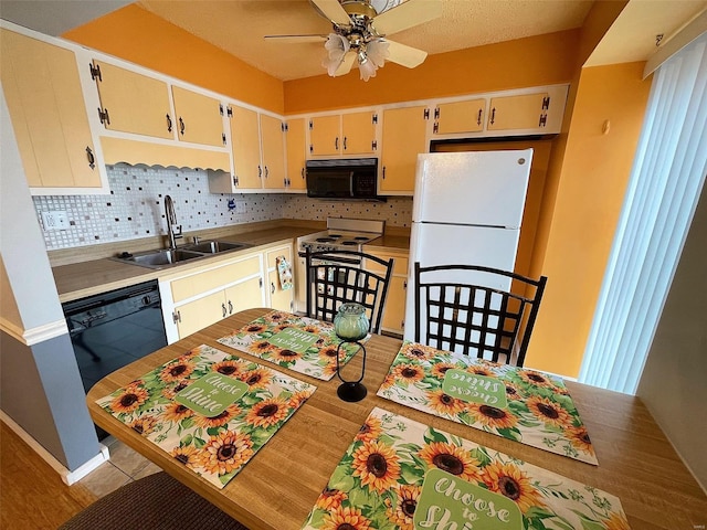 kitchen with tasteful backsplash, ceiling fan, sink, black appliances, and light hardwood / wood-style floors