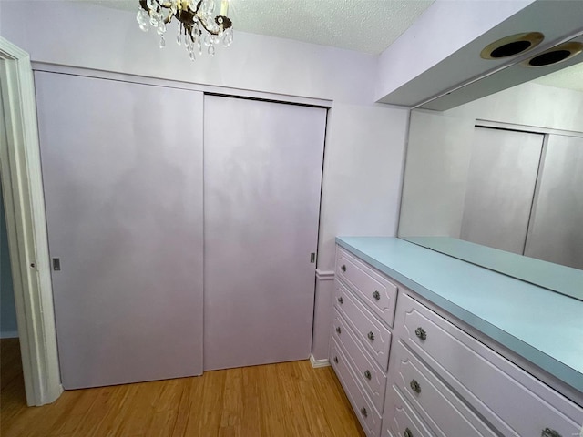 walk in closet featuring light hardwood / wood-style flooring and a notable chandelier