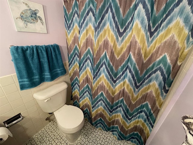 bathroom featuring a shower with curtain, tile walls, and toilet