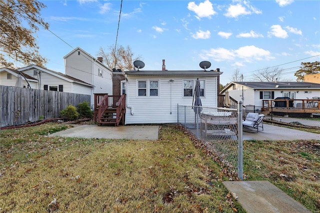 rear view of house featuring a deck, a yard, and a patio