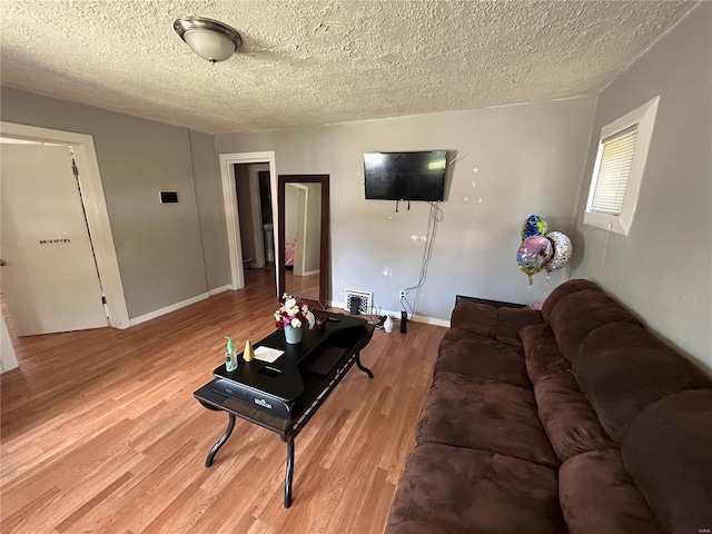 living room featuring a textured ceiling and light hardwood / wood-style flooring