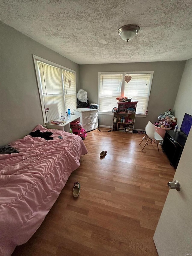 bedroom featuring hardwood / wood-style floors and a textured ceiling