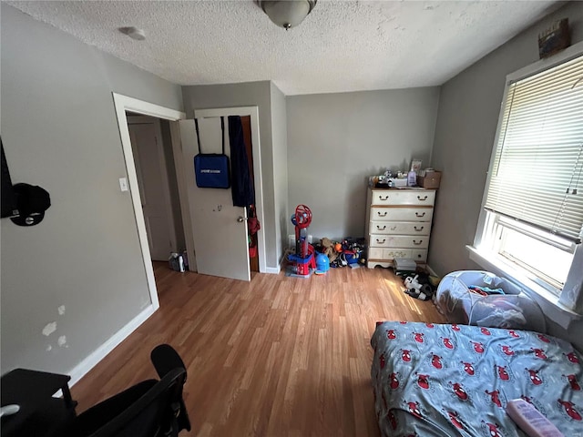 bedroom with a textured ceiling and hardwood / wood-style flooring