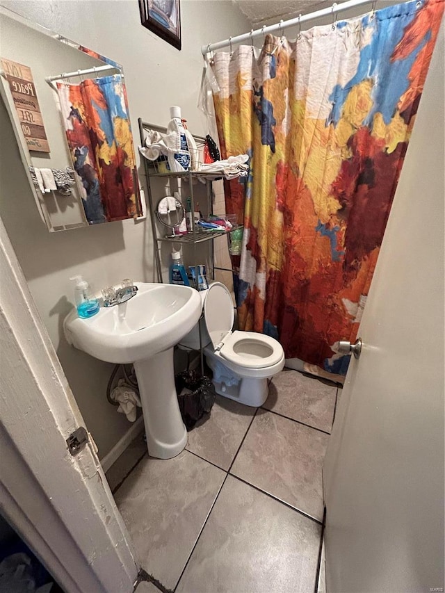 bathroom featuring tile patterned floors, curtained shower, and toilet