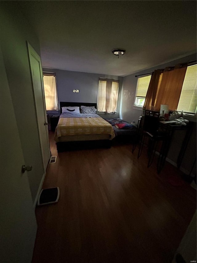 bedroom with dark hardwood / wood-style floors