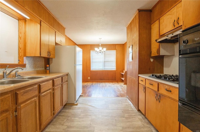 kitchen with stainless steel gas stovetop, sink, a notable chandelier, light hardwood / wood-style floors, and hanging light fixtures