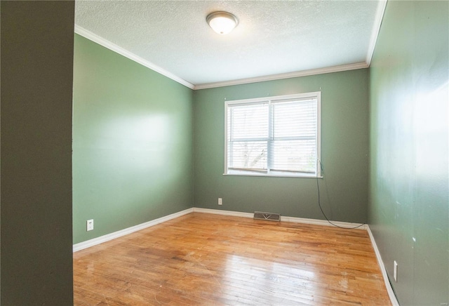 unfurnished room featuring wood-type flooring, a textured ceiling, and ornamental molding